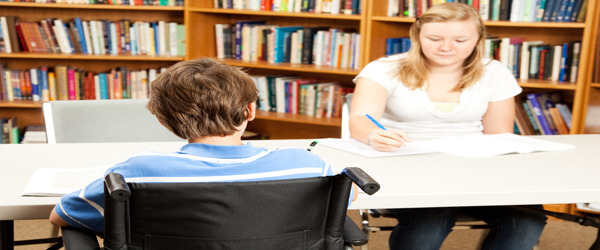 Un joven con discapacidad estudia en la biblioteca junto a una compañera. Foto cedida por depositphotos.com. Autora: Lisa F. Young