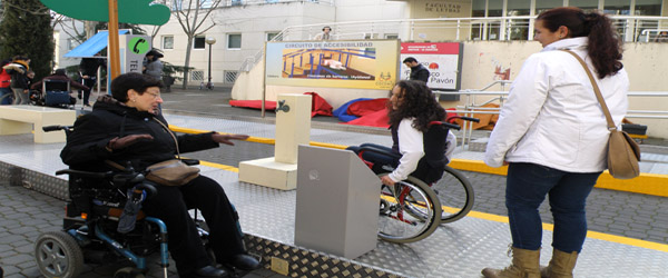 Una voluntaria con movilidad reducida instruye a una de las jóvenes