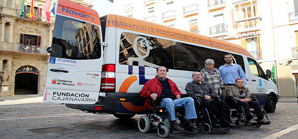 Usuarios del transporte adaptado de COCEMFE Navarra junto a una de las furgonetas
