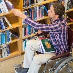Persona en silla de ruedas en una biblioteca