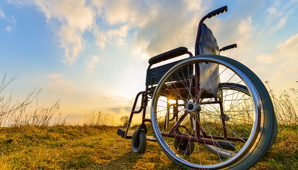 Empty wheelchair on the meadow at sunset Credito-bubutu