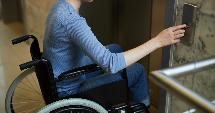 Una mujer utilizando un ascensor en un edificio accesible