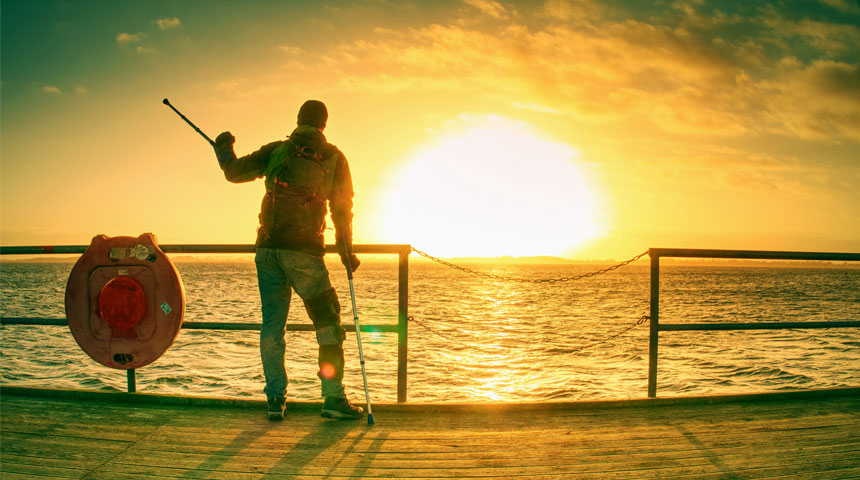 Hombre con muletas en muelle