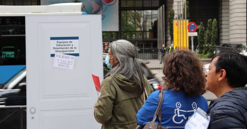 Personas esperando la valoración haciendo fila tras una puerta