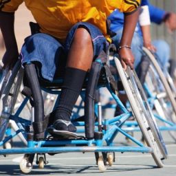 Jugadores en silla de ruedas compiten en una actividad de baloncesto adaptado durante una jornada inclusiva de deporte.