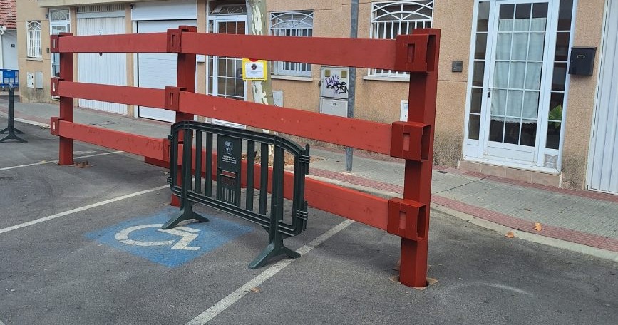Plaza para personas con discapacidad bloqueada por un vallado de madera durante festejos en Villanueva del Pardillo.