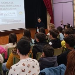 Persona de COGAMI impartiendo una charla de sensibilización sobre discapacidad ante alumnado de un centro educativo en Galicia.
