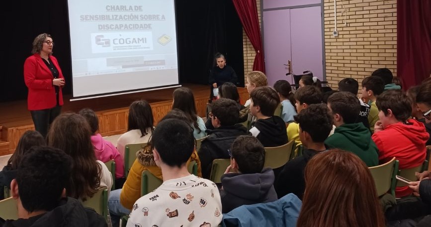 Persona de COGAMI impartiendo una charla de sensibilización sobre discapacidad ante alumnado de un centro educativo en Galicia.