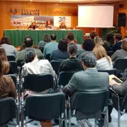 Personas asistentes escuchan a ponentes en la jornada sobre igualdad organizada por COCEMFE Badajoz en su salón de actos.
