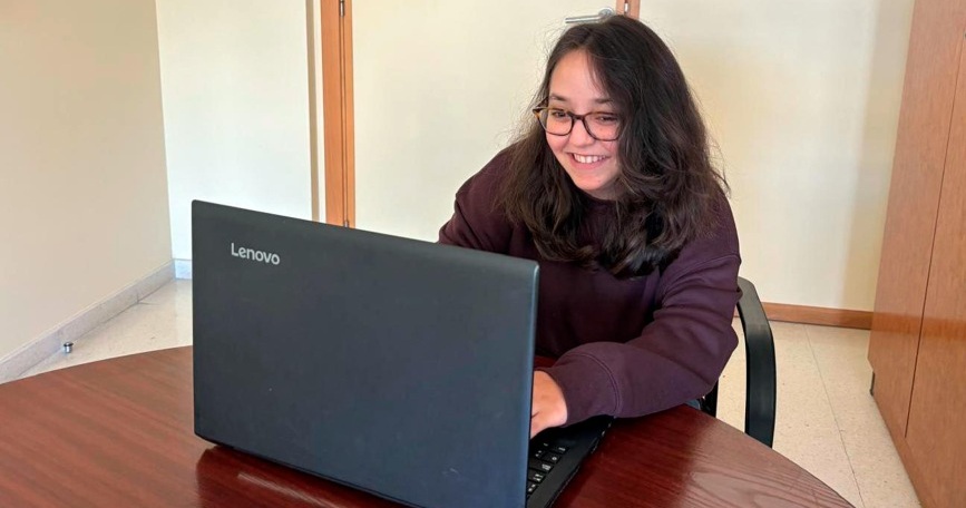 Joven con discapacidad utilizando un ordenador portátil en un entorno de trabajo, símbolo del acceso al empleo inclusivo promovido por COGAMI en Galicia.