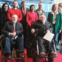 Grupo de personas participantes en el acto de Fekoor por el Día Internacional de las Personas con Discapacidad, con dos hombres usuarios de silla de ruedas en primer plano.