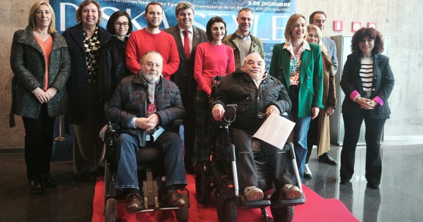 Grupo de personas participantes en el acto de Fekoor por el Día Internacional de las Personas con Discapacidad, con dos hombres usuarios de silla de ruedas en primer plano.