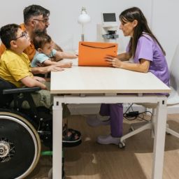 Profesional asesora a una familia con menores con discapacidad en un servicio de mediación educativa inclusiva.