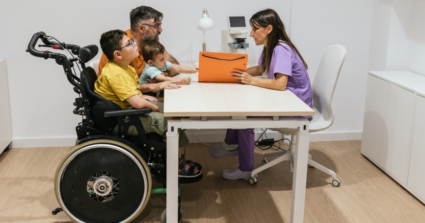 Profesional asesora a una familia con menores con discapacidad en un servicio de mediación educativa inclusiva.