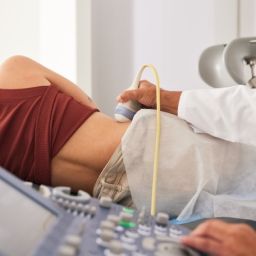 Profesional sanitario realiza una prueba médica a una mujer en consulta, imagen relacionada con enfermedad renal crónica y tratamiento renal sustitutivo.