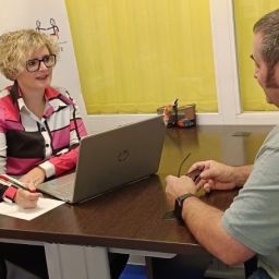 Profesional de CLM INCLUSIVA COCEMFE realizando una sesión de orientación laboral con una persona usuaria en una oficina.