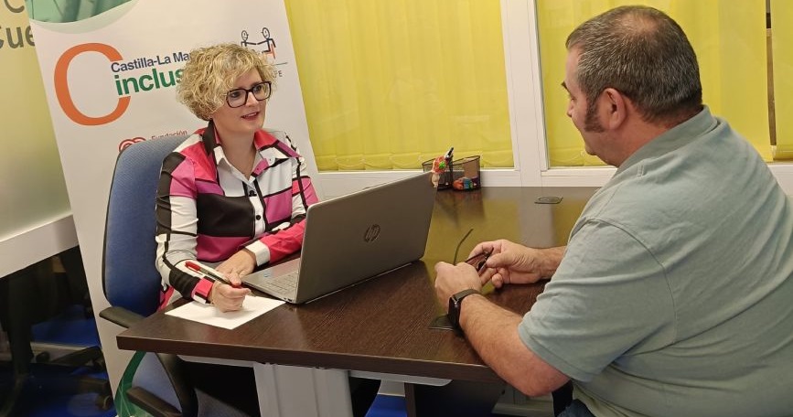 Profesional de CLM INCLUSIVA COCEMFE realizando una sesión de orientación laboral con una persona usuaria en una oficina.
