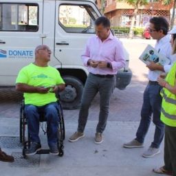 Personas evaluando la accesibilidad de un espacio urbano junto a una persona usuaria de silla de ruedas.