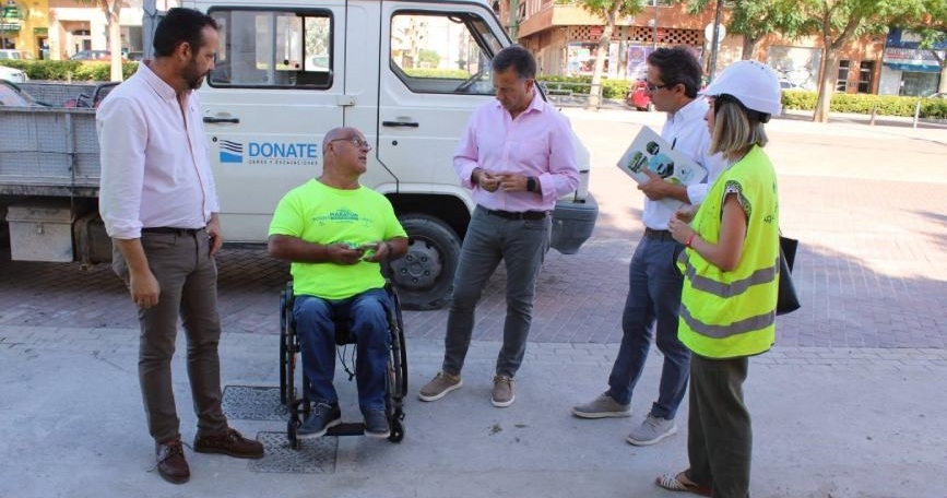 Personas evaluando la accesibilidad de un espacio urbano junto a una persona usuaria de silla de ruedas.