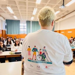 Ponente de COCEMFE Alicante imparte una charla a estudiantes de Trabajo Social en un aula de la Universidad de Alicante.