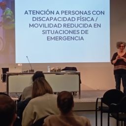 Ponencia sobre atención a personas con discapacidad en situaciones de emergencia ante público asistente.