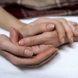 Dos personas se cogen de la mano en un gesto de apoyo y acompañamiento