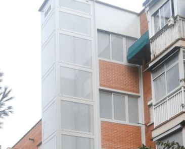 Edificio con ascensor exterior accesible Edificio de viviendas con ascensor exterior que mejora la accesibilidad residencial