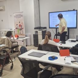 Personas con discapacidad participan en un curso de formación con docente explicando en pantalla digital