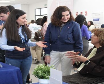 IV Feria de Empleo de COCEMFE Sevilla en La Rinconada Participantes conversan en un estand de la IV Feria de Empleo de COCEMFE Sevilla con una mujer usuaria de silla de ruedas.