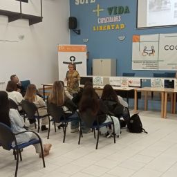 Técnicas de COCEMFE Cáceres presentan la Oficina de Vida Independiente y Autónoma ante personas asistentes en una sala de formación.