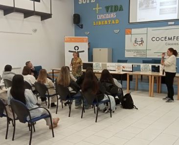 Presentación de la OVIACC de COCEMFE Cáceres Técnicas de COCEMFE Cáceres presentan la Oficina de Vida Independiente y Autónoma ante personas asistentes en una sala de formación.