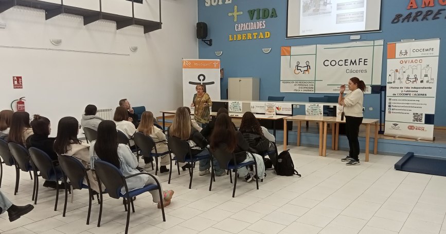 Técnicas de COCEMFE Cáceres presentan la Oficina de Vida Independiente y Autónoma ante personas asistentes en una sala de formación.