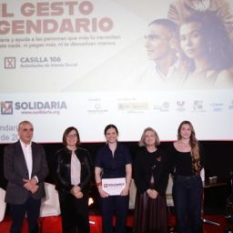 Personas participantes en la presentación de la campaña X Solidaria “El gesto legendario” en un escenario con pantalla informativa al fondo