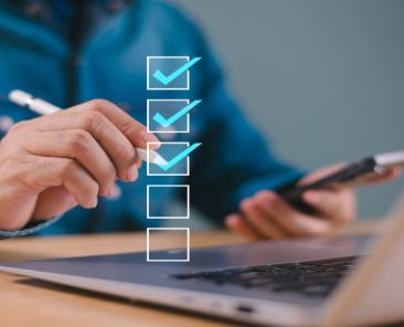 Cuestionario digital sobre barreras sociosanitarias Persona completando un cuestionario online en ordenador y móvil con lista de verificación