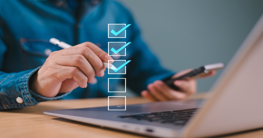 Persona completando un cuestionario online en ordenador y móvil con lista de verificación