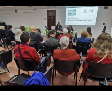 Charla sobre accesibilidad urbana de COCEMFE CV con asistentes en sala y presentación proyectada en Alcàsser