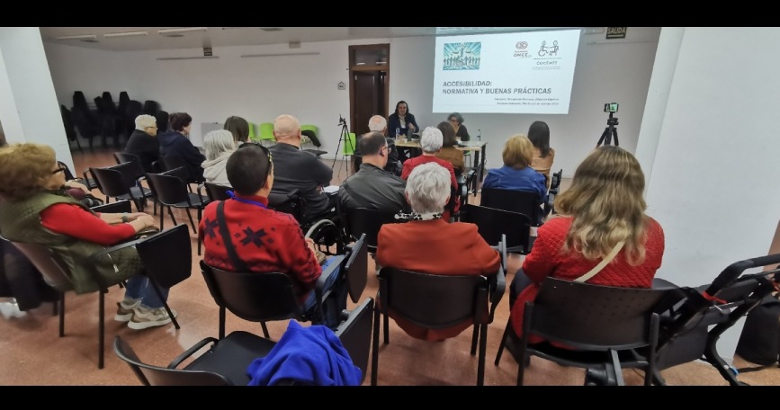 Charla sobre accesibilidad urbana de COCEMFE CV con asistentes en sala y presentación proyectada en Alcàsser