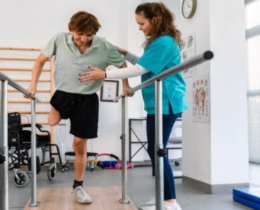 Rehabilitación física con apoyo profesional en entorno sanitario accesible Persona con discapacidad realiza ejercicios de rehabilitación con apoyo de profesional sanitaria en un centro accesible