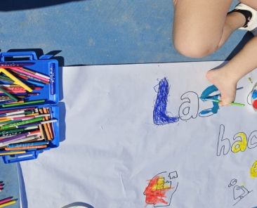 Niño pintando un mural en una actividad de sensibilización sobre discapacidad en un centro educativo