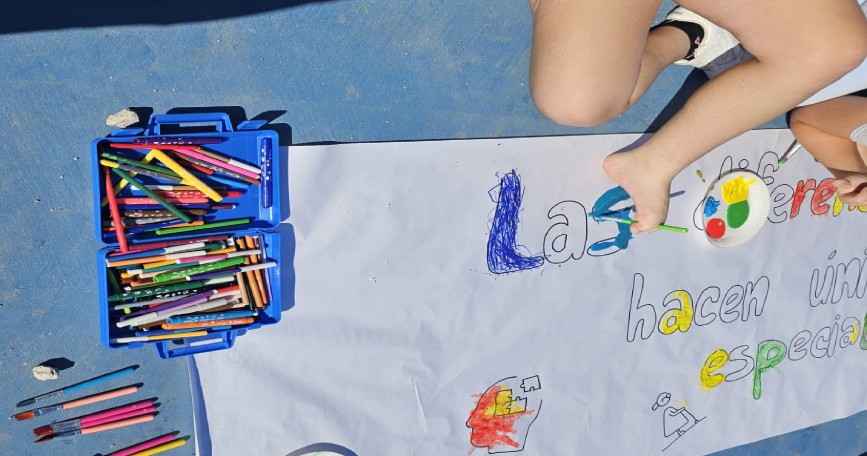 Niño pintando un mural en una actividad de sensibilización sobre discapacidad en un centro educativo