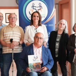 Representantes de COCEMFE Albacete durante la Asamblea General junto al panel del 35 aniversario de la entidad.