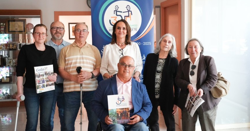 Representantes de COCEMFE Albacete durante la Asamblea General junto al panel del 35 aniversario de la entidad.