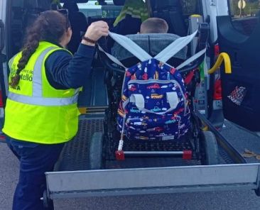 Acceso de una persona en silla de ruedas a un vehículo adaptado con ayuda profesional
