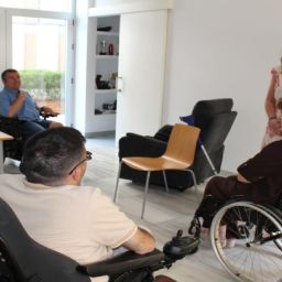 Personas usuarias de silla de ruedas y representantes institucionales visitan viviendas accesibles cedidas a COCEMFE Sevilla para un proyecto de vida independiente.