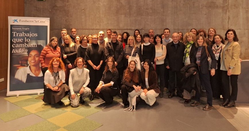Representantes de entidades sociales participantes en el programa Incorpora posan durante un encuentro territorial junto a un expositor de Fundación "la Caixa".
