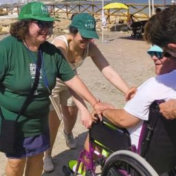 Participación inclusiva en La Mar Solidaria de Alicante Persona usuaria de silla de ruedas participa en una actividad en la playa junto a personas voluntarias durante La Mar Solidaria en Alicante.
