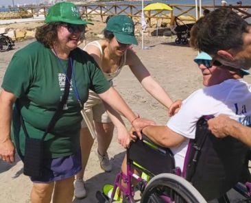 Participación inclusiva en La Mar Solidaria de Alicante Persona usuaria de silla de ruedas participa en una actividad en la playa junto a personas voluntarias durante La Mar Solidaria en Alicante.