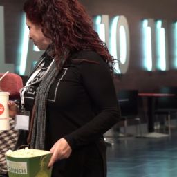 Apoyos para la vida independiente y la participación social de las personas con discapacidad Mujer con discapacidad acompañada por una profesional de apoyo durante una actividad de ocio en un cine, promoviendo la autonomía personal y la inclusión social.