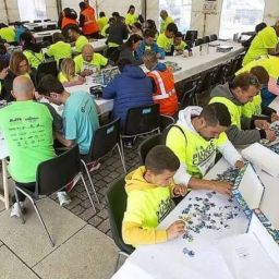 Personas participantes y voluntarias realizan una prueba de montaje de puzzles durante el Puzzle Cross organizado por COCEMFE Castilla y León.