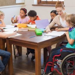 Educación inclusiva en el aula Docente y grupo de escolares, entre ellos un alumno usuario de silla de ruedas, participan juntos en una actividad en un aula inclusiva.